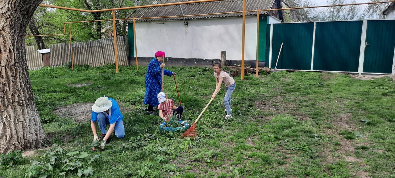 Семья из Султана наводит порядок около дома.